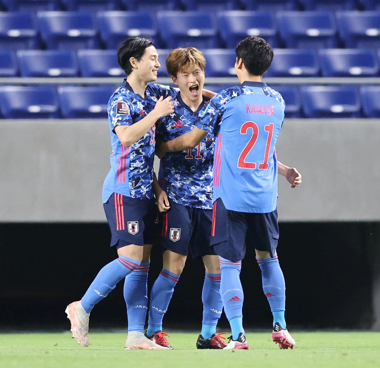 日本対タジキスタン　前半、先制ゴールを決めた古橋（中央）は川辺（右）ら仲間の祝福に笑顔を見せる。左は南野（撮影・垰建太）