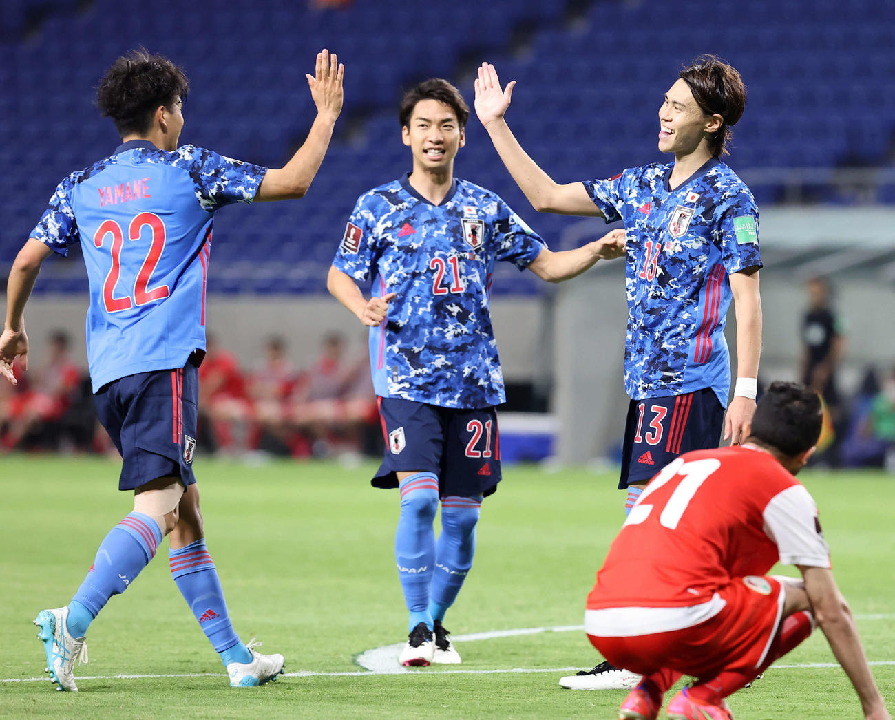 日本対タジキスタン　後半、代表初ゴールを決めた橋本（右）は山根（左）と笑顔でハイタッチ。中央は川辺（撮影・垰建太）