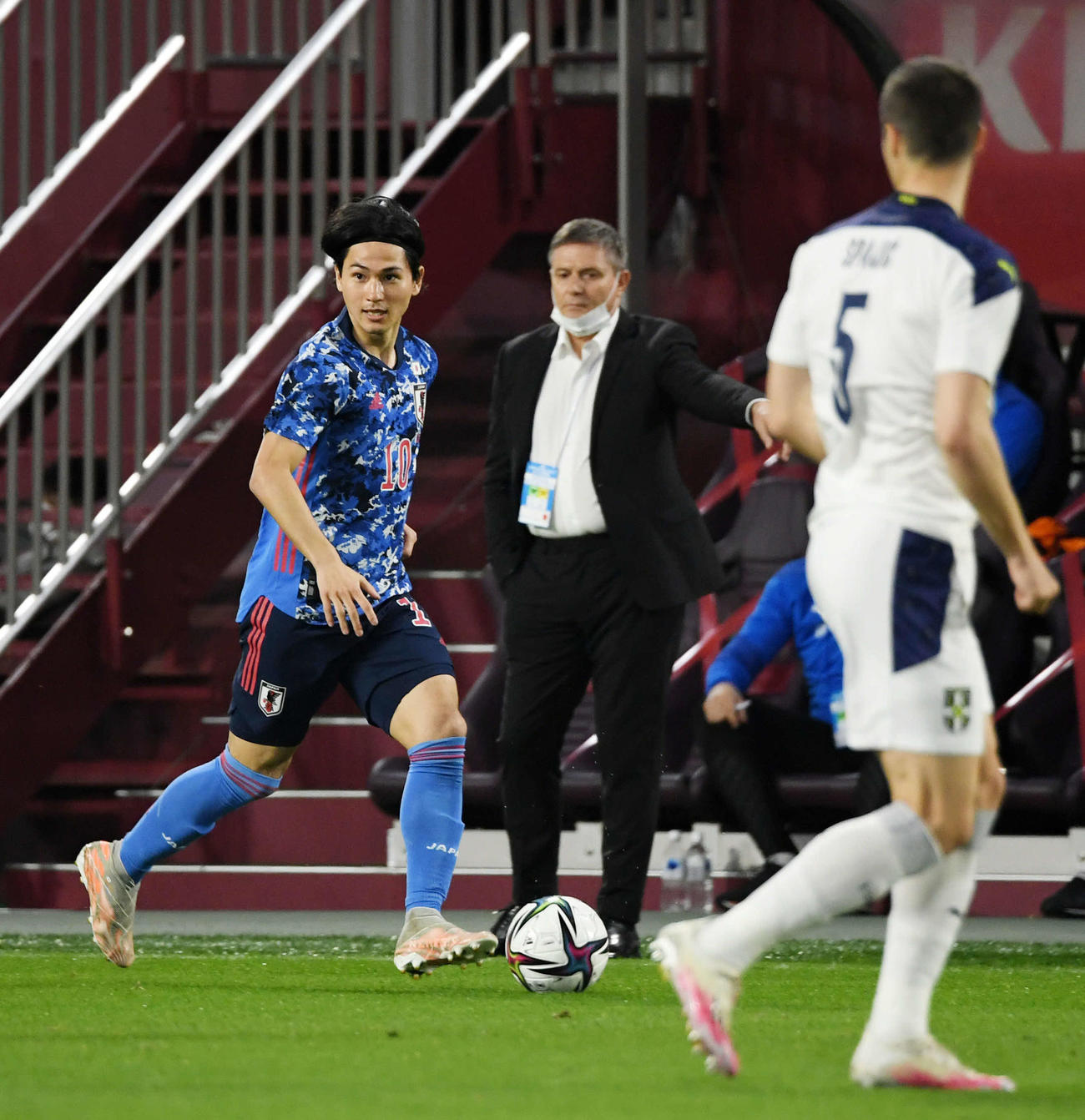 日本対セルビア　前半、ドリブルする南野拓実。後方はストイコビッチ監督（撮影・横山健太）
