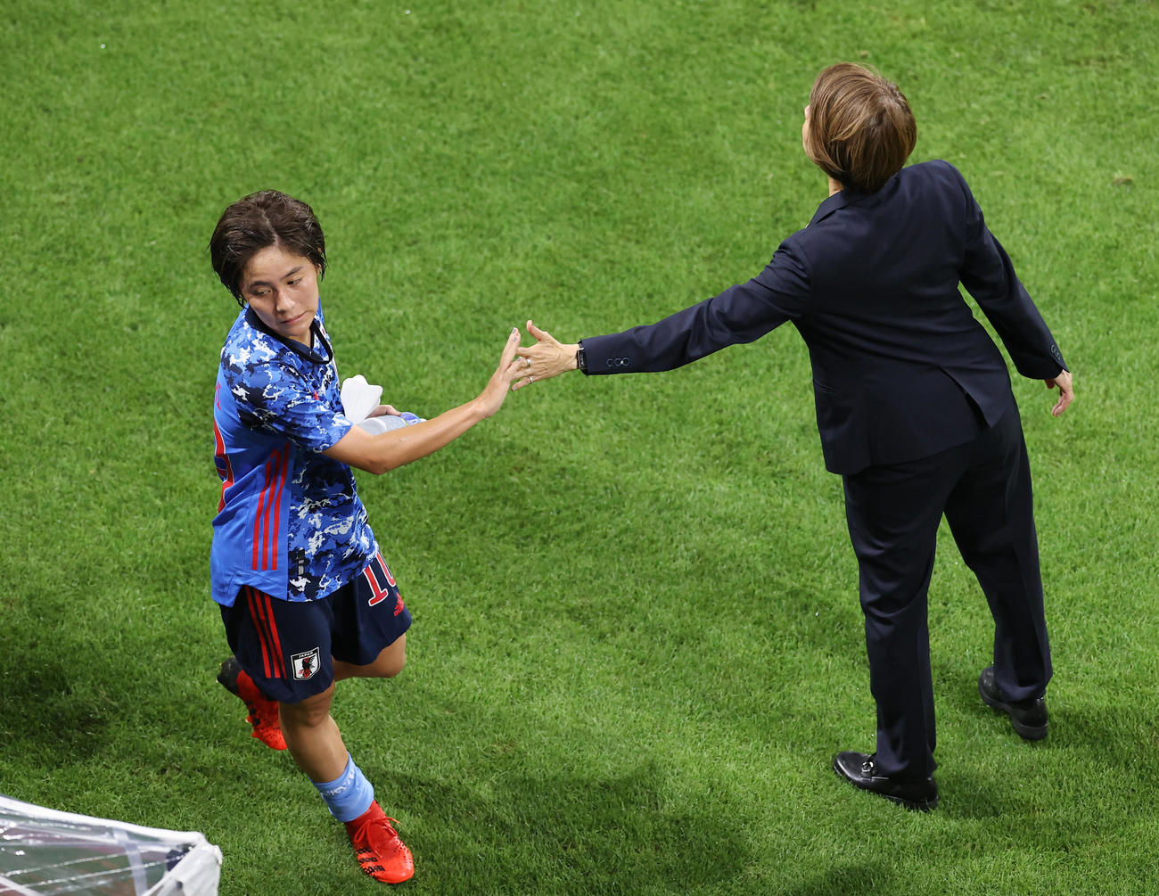 日本対オーストラリア　後半、交代でベンチに下がる日本の岩渕（左）は高倉監督とタッチを交わす（撮影・垰建太）