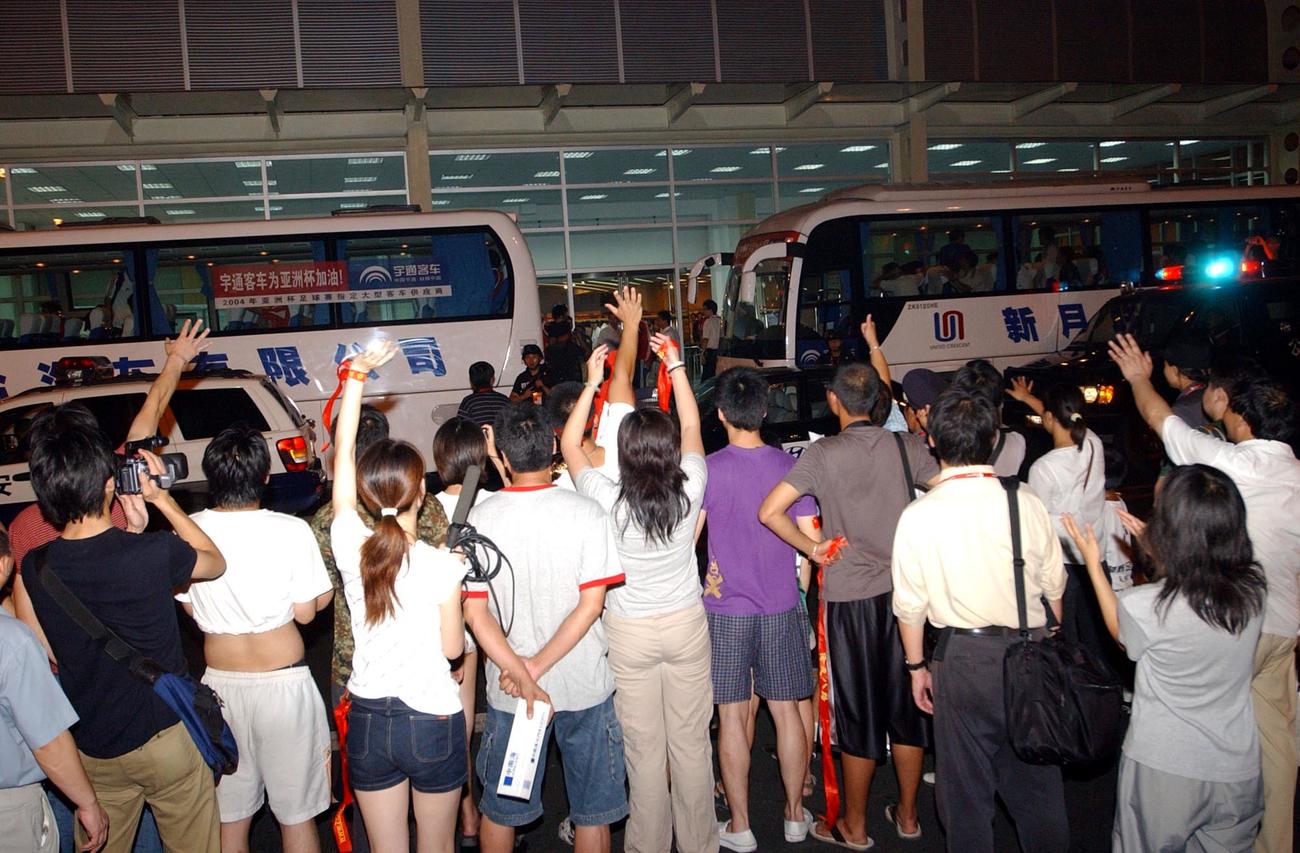 決勝戦後、中国代表のバス（左）に声援と罵声を送る中国人サポーター。日本代表のバスは出られず待つしかなかった（2004年8月7日撮影）