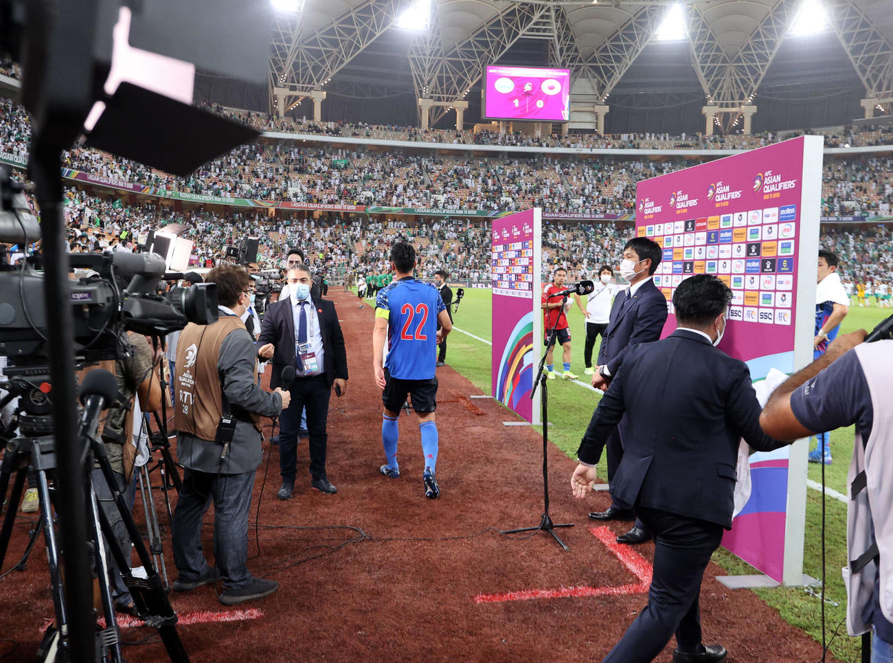 サウジアラビア対日本　サウジアラビア戦に敗れテレビのインタビューを受ける日本代表森保監督。中央はピッチを引き揚げる吉田（撮影　パオロ・ヌッチ）