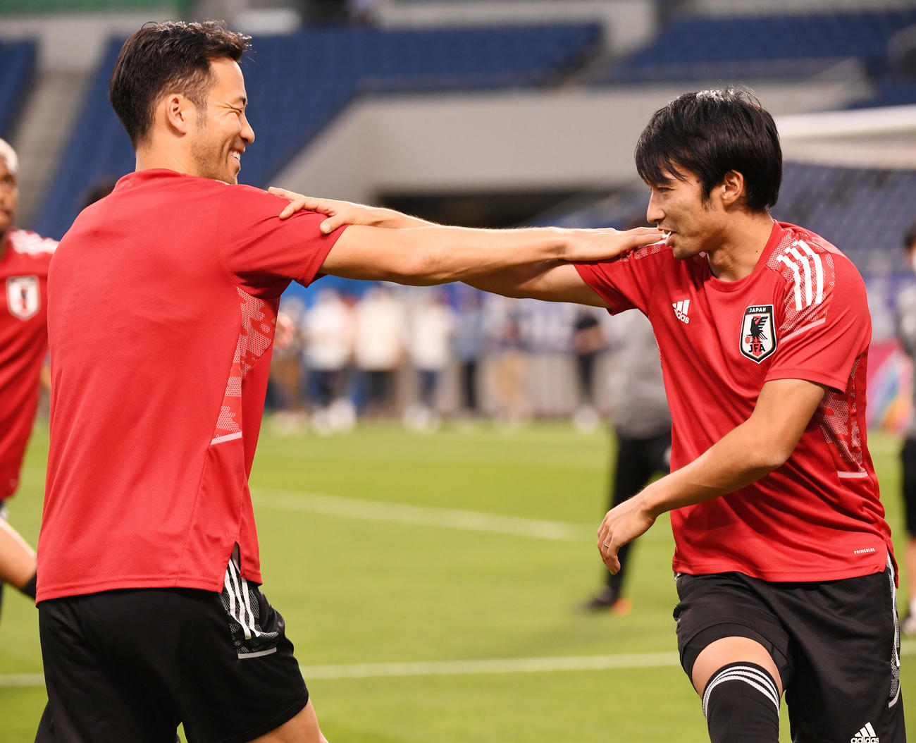 談笑しながらストレッチをする吉田（左）と柴崎（撮影・横山健太）