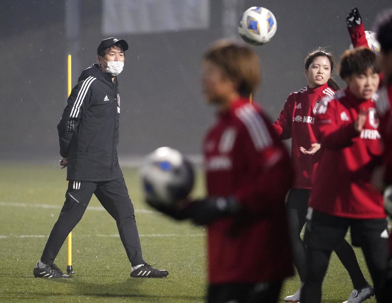 女子アジア杯に向けた合宿を開始し、練習を見守る池田監督（左）（共同）