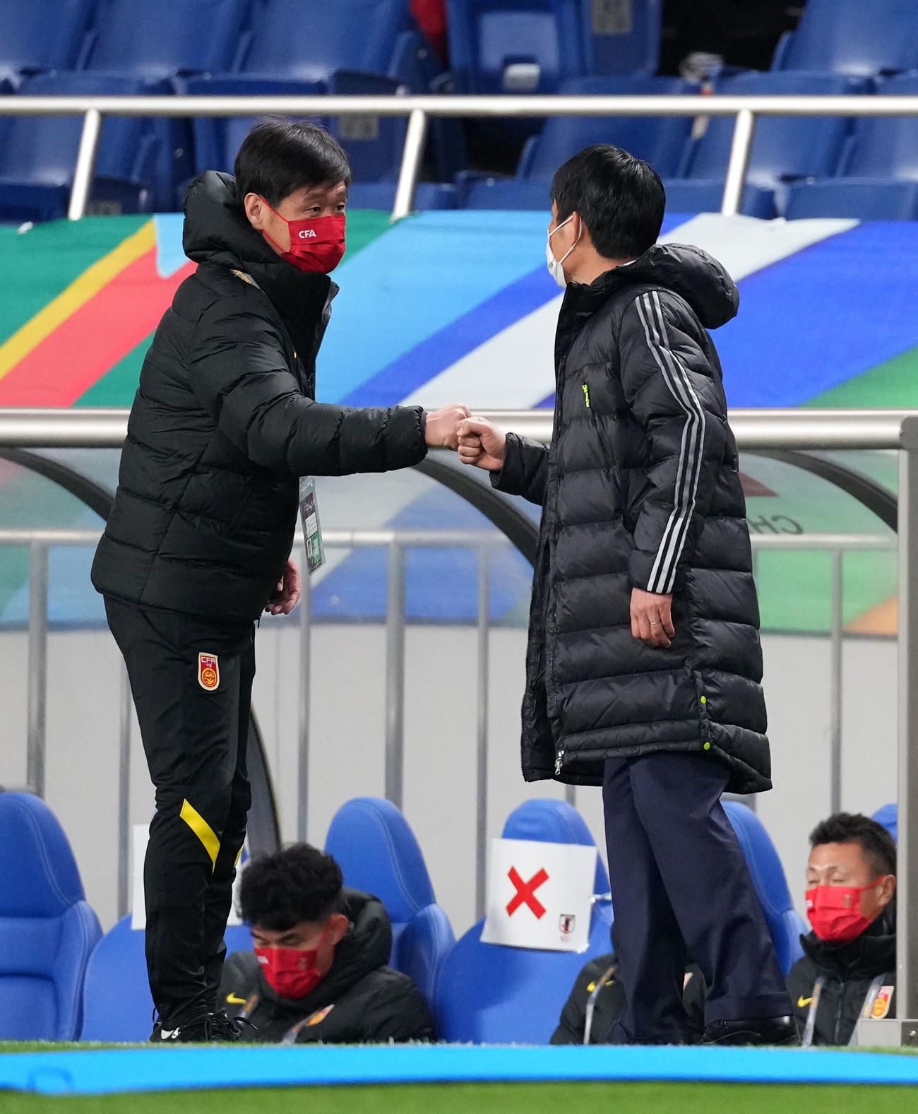 日本対中国　試合前にグータッチを交わす日本の森保（右）、中国の李霄鵬両監督（撮影・横山健太）