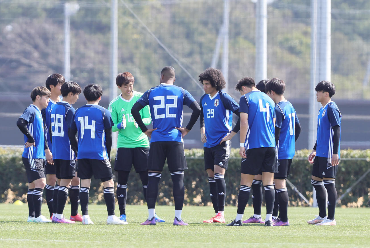 練習試合　U－21日本代表候補対横浜　後半開始前の円陣で笑みを浮かべるチェイス・アンリ（中央右）（撮影・足立雅史）