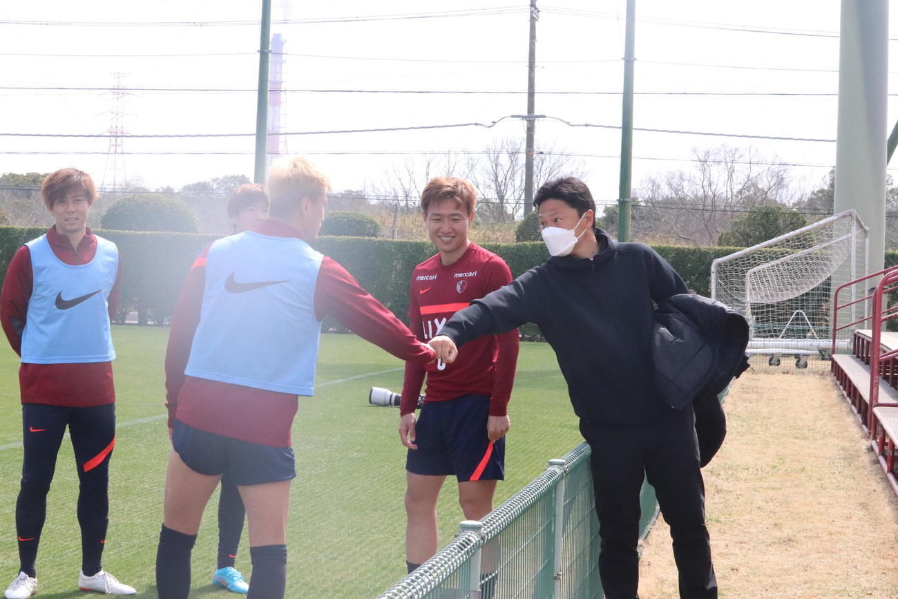 パリ五輪を指揮する大岩剛監督（右）が視察に訪れ、FW鈴木とグータッチをする。大岩監督とともにアジア制覇した（左から）DF安西、三竿もあいさつした