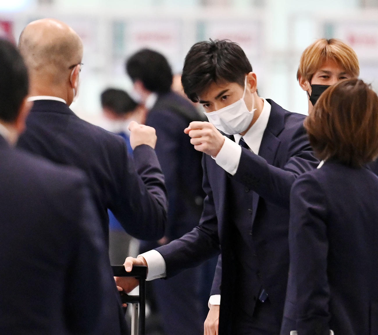羽田空港に到着しスタッフとタッチを交わす谷口（撮影・横山健太）