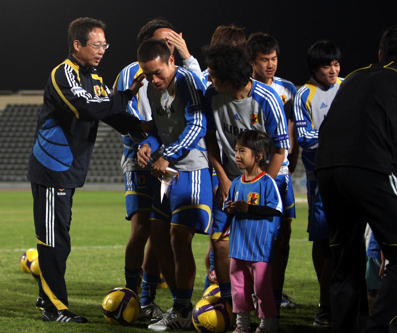 子供たちとの記念撮影で岡田武史監督（左）はDF長友佑都に「おまえも小さいから前列に座って」とふざけて言う（08年11月16日撮影）