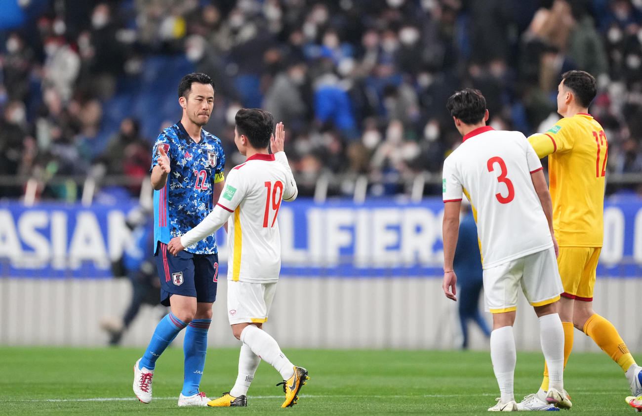 日本対ベトナム　引き分けに終わり、相手選手とタッチを交わす吉田（左）（撮影・菅敏）