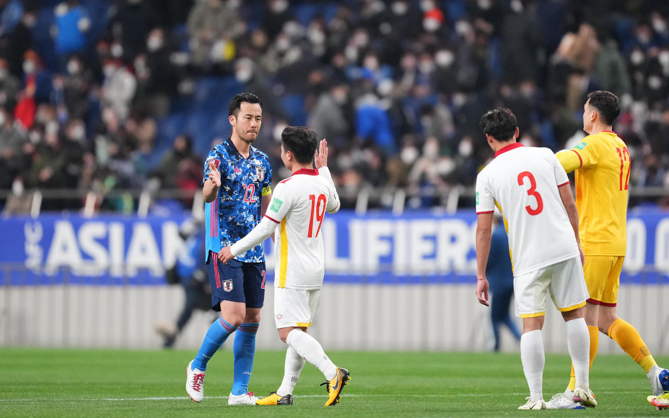 日本対ベトナム　引き分けに終わり、相手選手とタッチを交わす吉田（左）（撮影・菅敏）
