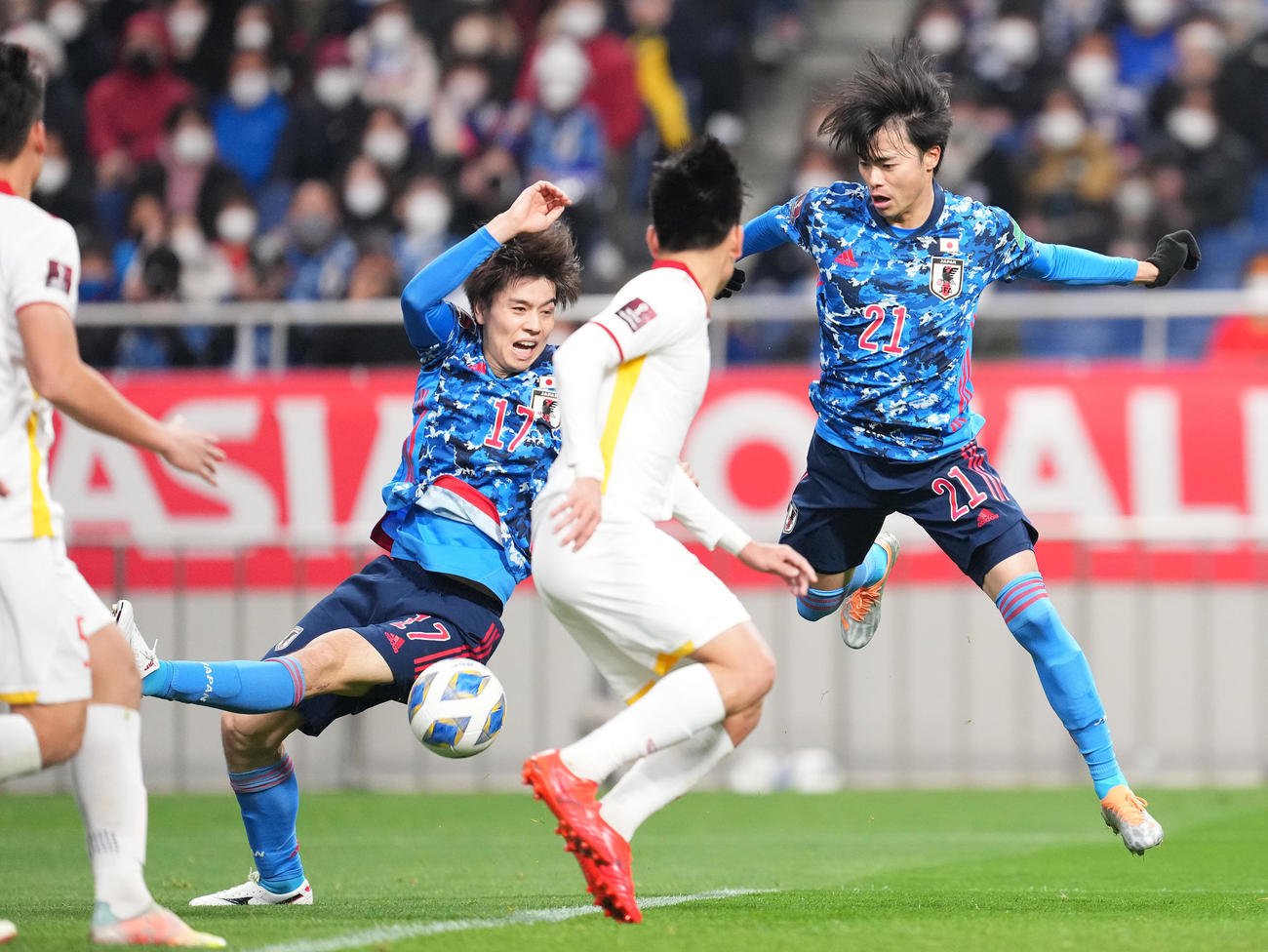 日本対ベトナム　後半、ゴール前で競り合い転倒する田中（左）。右は三笘（撮影・菅敏）