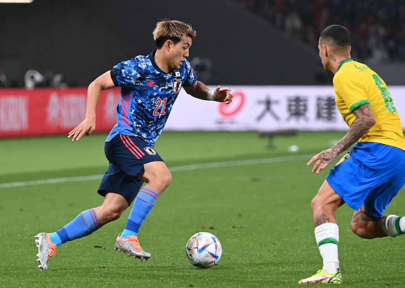 日本対ブラジル　後半、ドリブルする堂安（左）（撮影・横山健太）