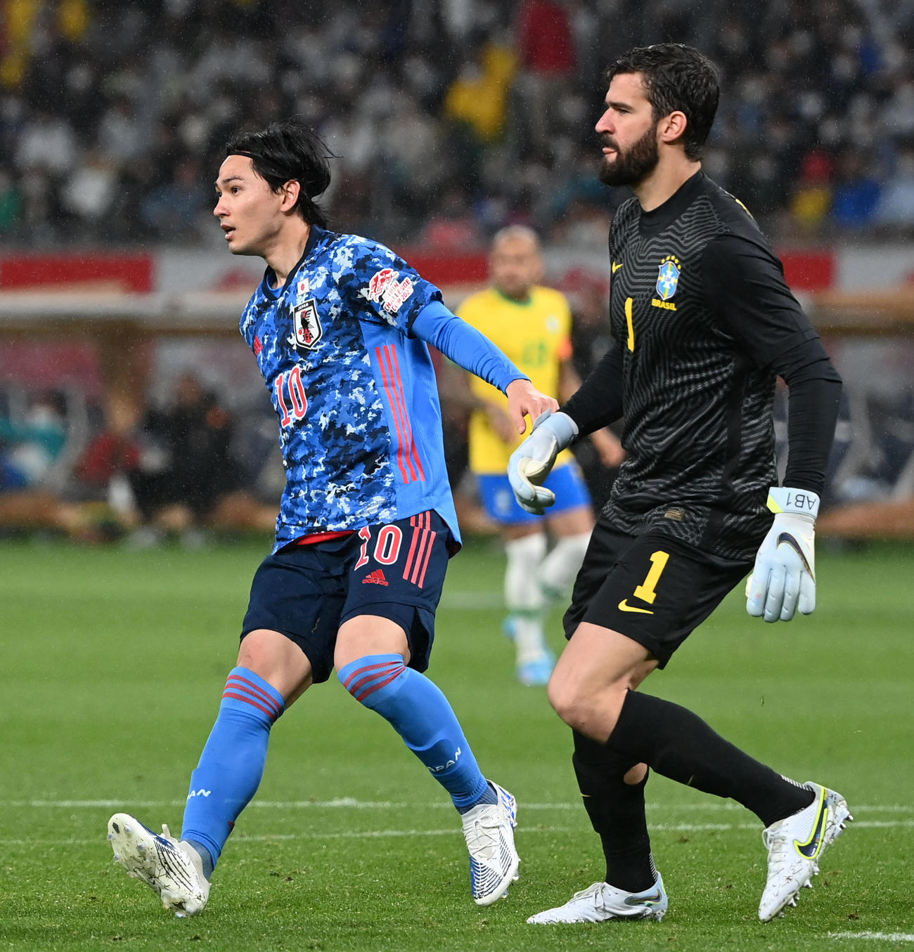 日本対ブラジル　後半、競り合う南野拓実（左）とGKアリソン（撮影・横山健太）