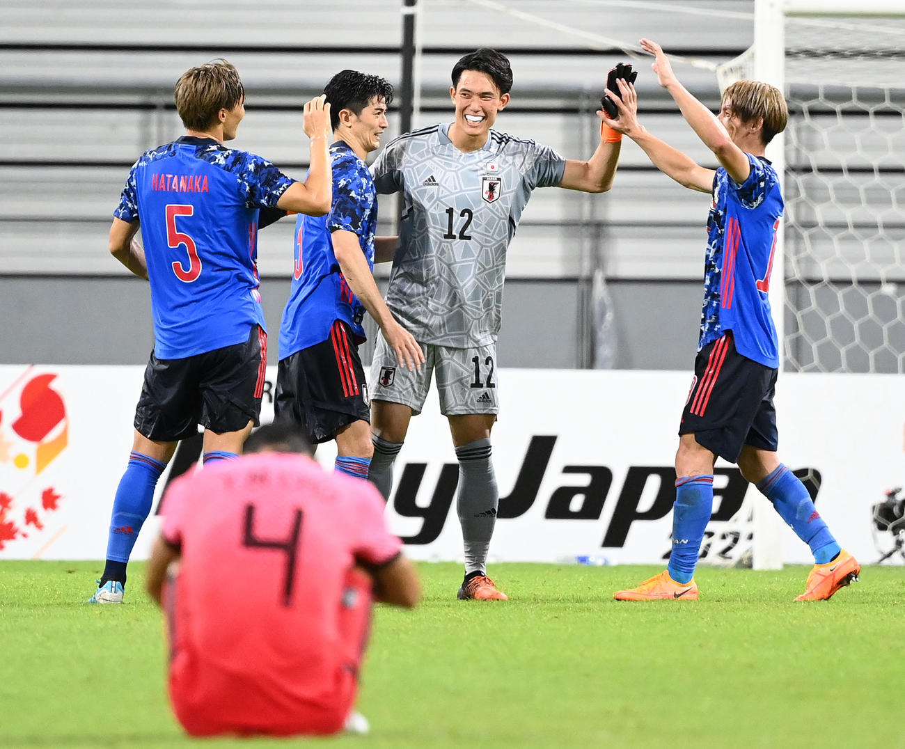 日本対韓国　韓国を破ってE－1選手権優勝を決め、笑顔でタッチを交わす、左から中谷、谷口、GK谷、佐々木（撮影・横山健太）