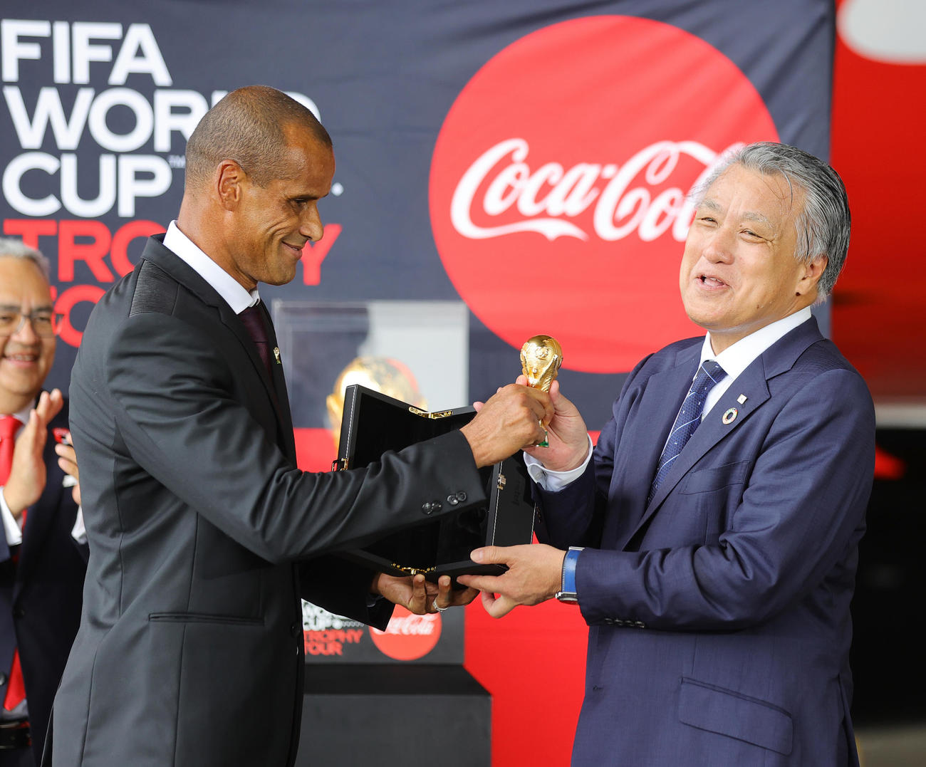 「コカ・コーラ　FIFA　ワールドカップトロフィーツアー」の到着セレモニーに出席し、元ブラジル代表のリバウド氏（左）からミニトロフィーを贈られ笑顔の日本サッカー協会・田嶋会長（撮影・野上伸悟）