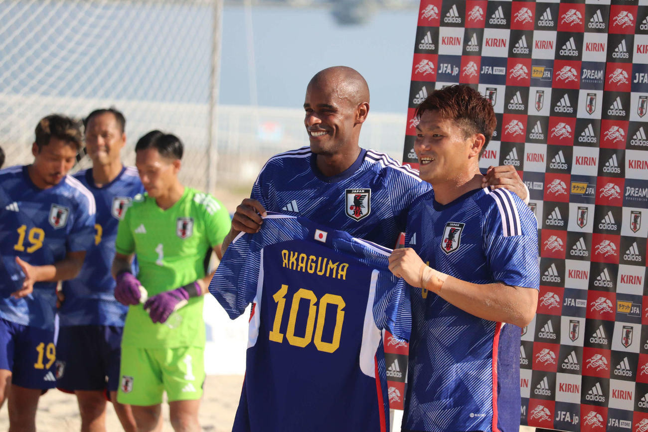 ビーチサッカー国際親善試合の日本－ウクライナで、国際Aマッチ通算100試合出場を達成し、茂怜羅選手兼監督（左）から記念のユニホームを受け取る赤熊卓弥（撮影・波部俊之介）2022年10月1日、兵庫・明石市内