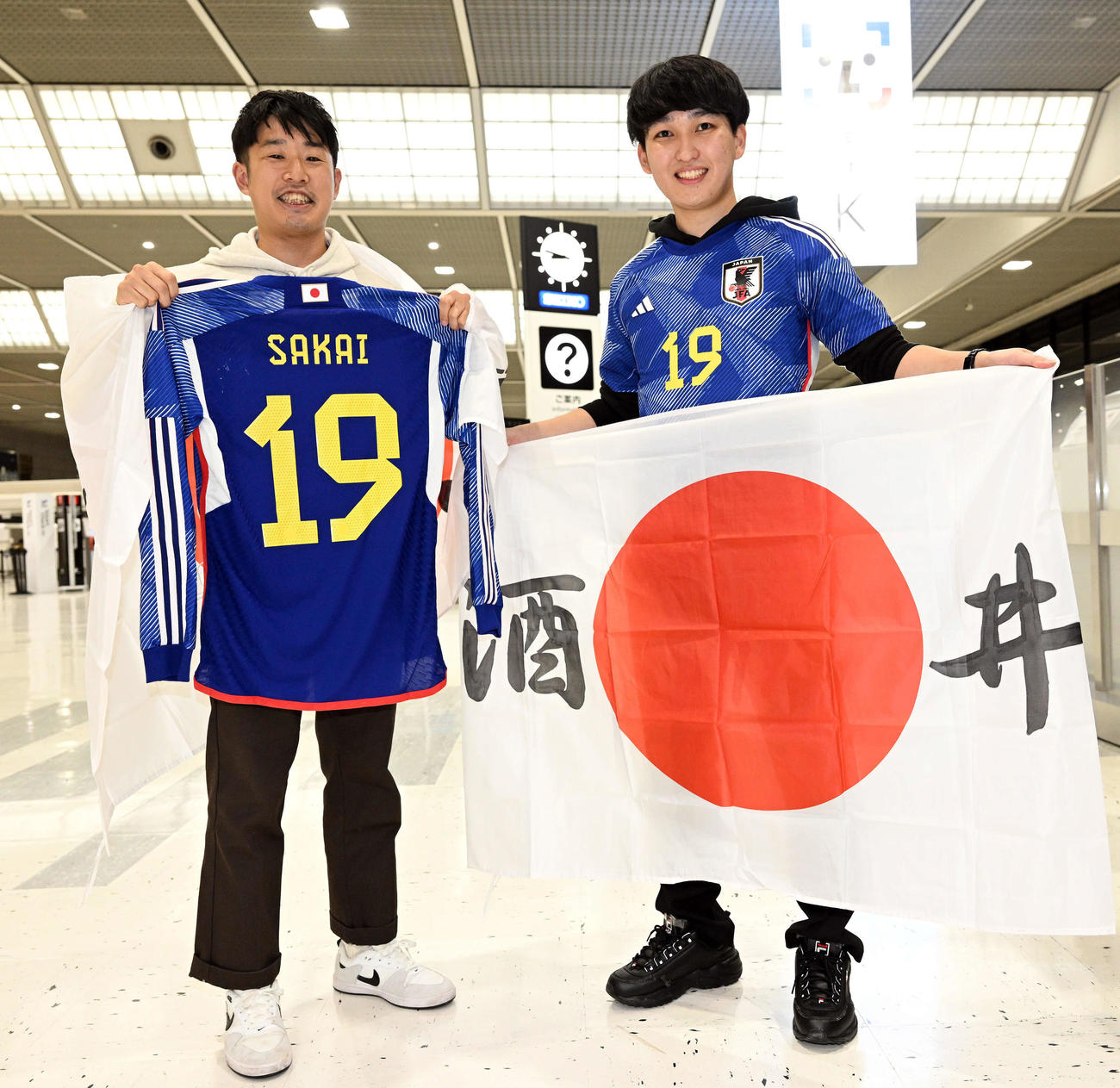 応援グッズを手に見送ったカタールに出発する日本代表の酒井が取締役を務める株式会社ASSISTのスタッフら（撮影・滝沢徹郎）