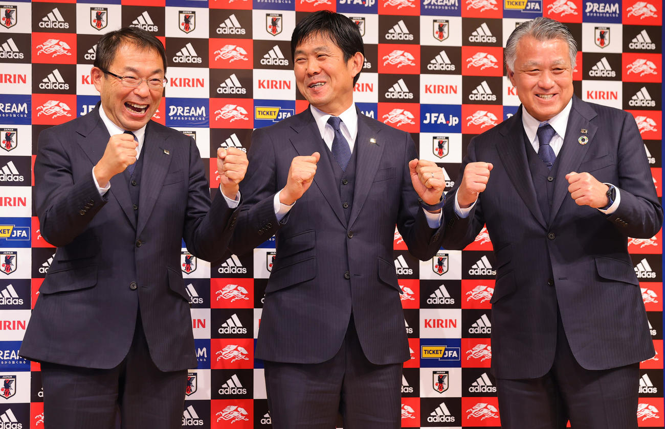 就任記者会見でガッツポーズする日本代表森保監督。右は日本サッカー協会田嶋会長、左は反町技術委員長（撮影・野上伸悟）