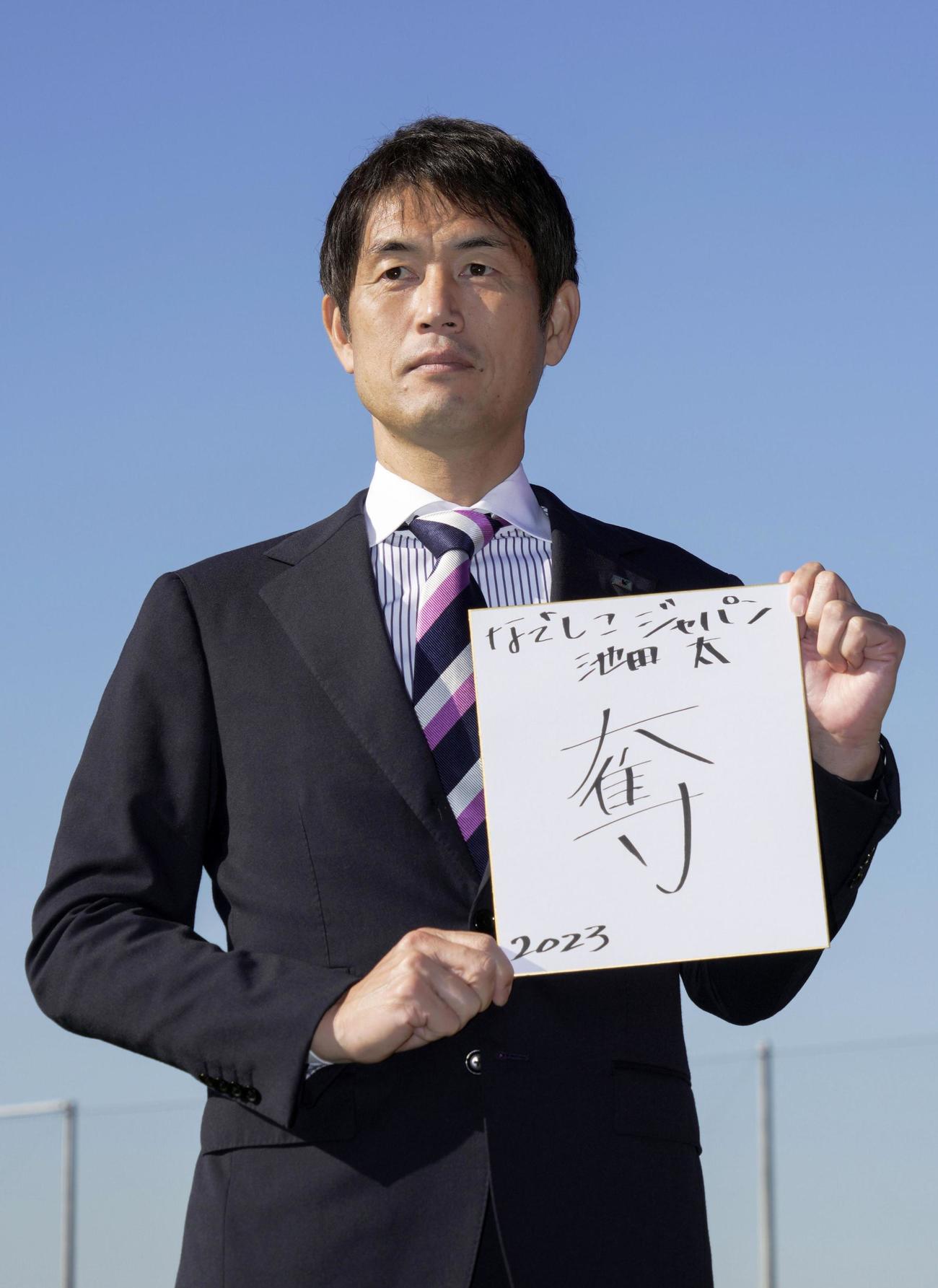 抱負を書いた色紙を手にするサッカーの女子日本代表なでしこジャパンの池田太監督
