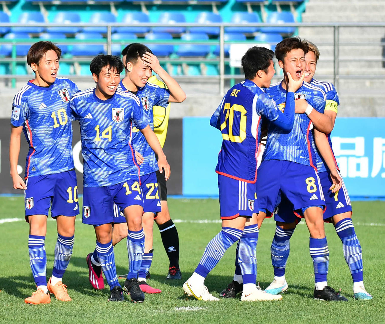 日本対キルギス　後半、PKで先制のゴールを決めた佐野（右手前）は松木（同後方）ら仲間に祝福され笑顔を見せる（C）AFC