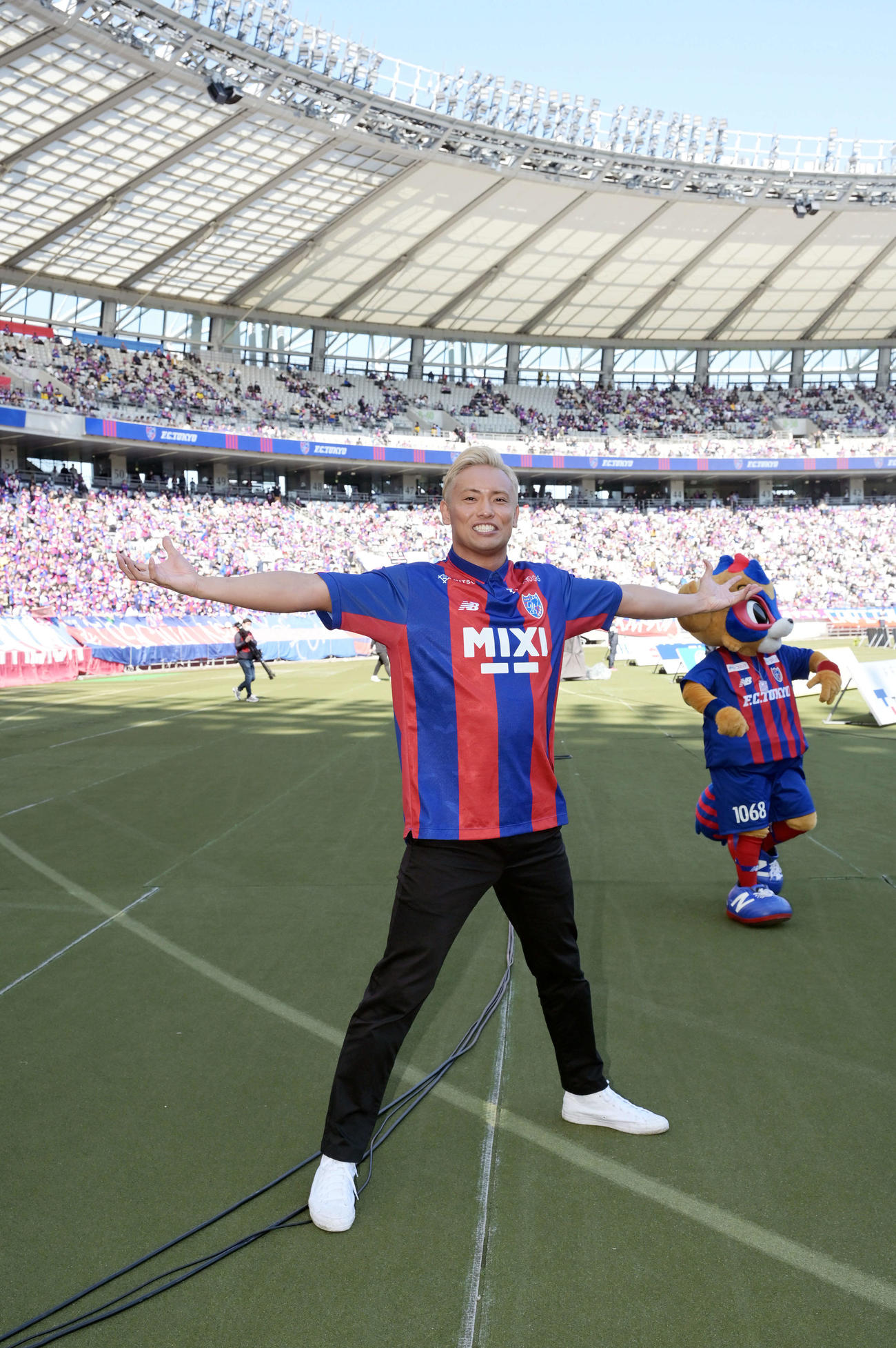 2023年4月9日、東京対湘南の試合前にサポーターへあいさつしたオカダ・カズチカはポーズを決める