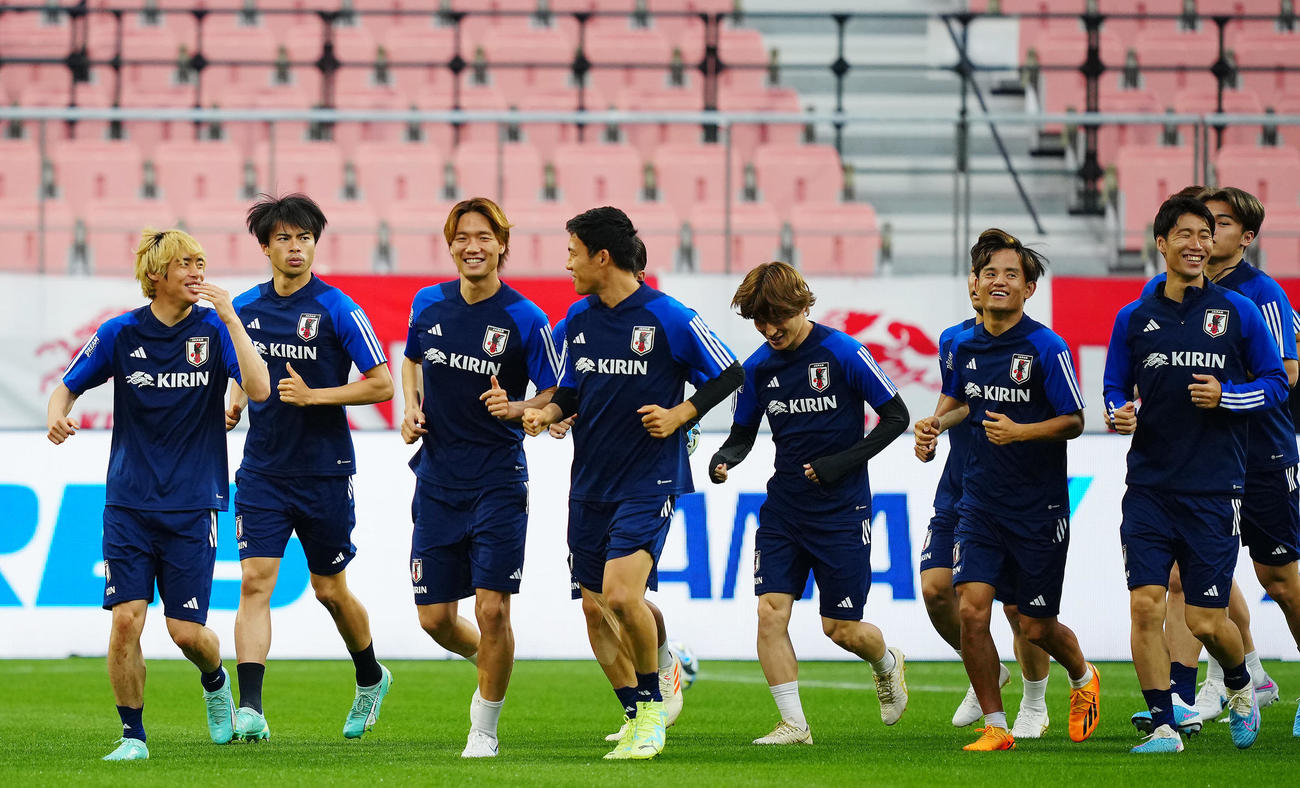 前日練習で板倉（左から3人目）ら選手たちが笑顔でウオーミングアップを行う中、集中した表情の三笘（同2人目）（撮影・垰建太）