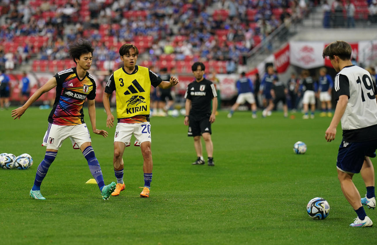 日本対エルサルバドル　試合前、ウオーミングアップをする三笘（左）と久保撮影・狩俣裕三）