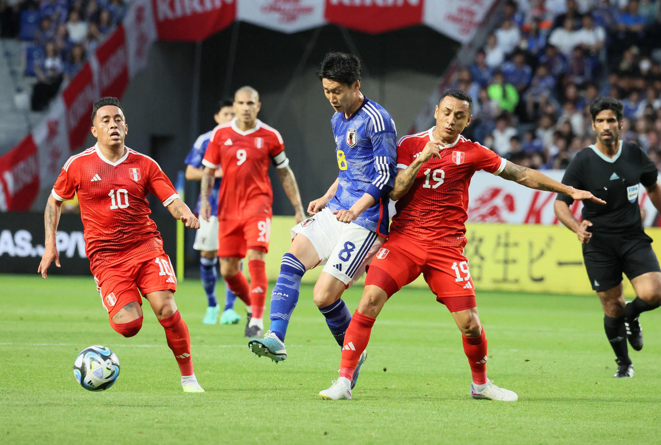 日本対ペルー　前半、ドリブルで攻め上がる鎌田（中央）。右はペルー・ジョトゥン、左はクエバ（撮影・加藤哉）
