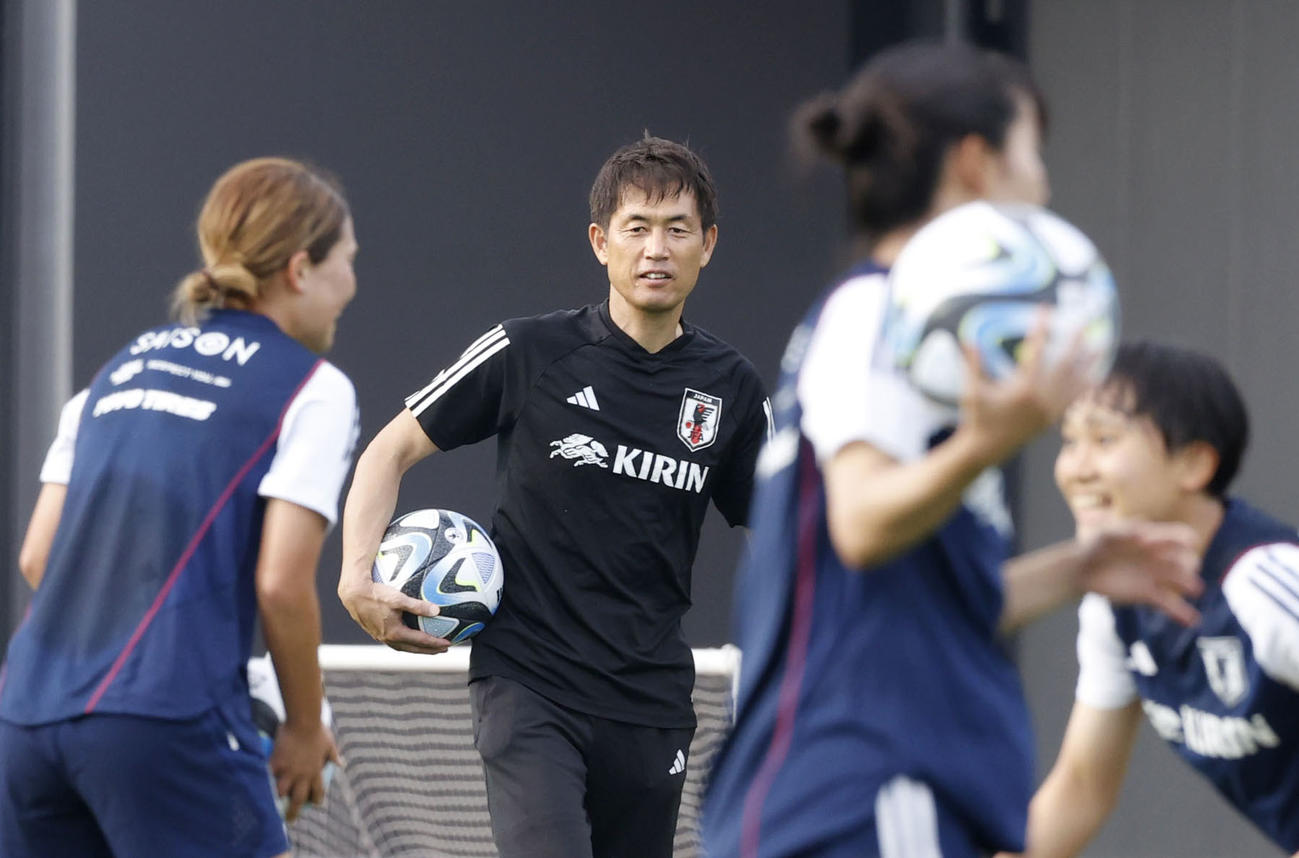 サッカー女子W杯に向けた合宿で、選手の練習を見守る池田監督（奥）（共同）