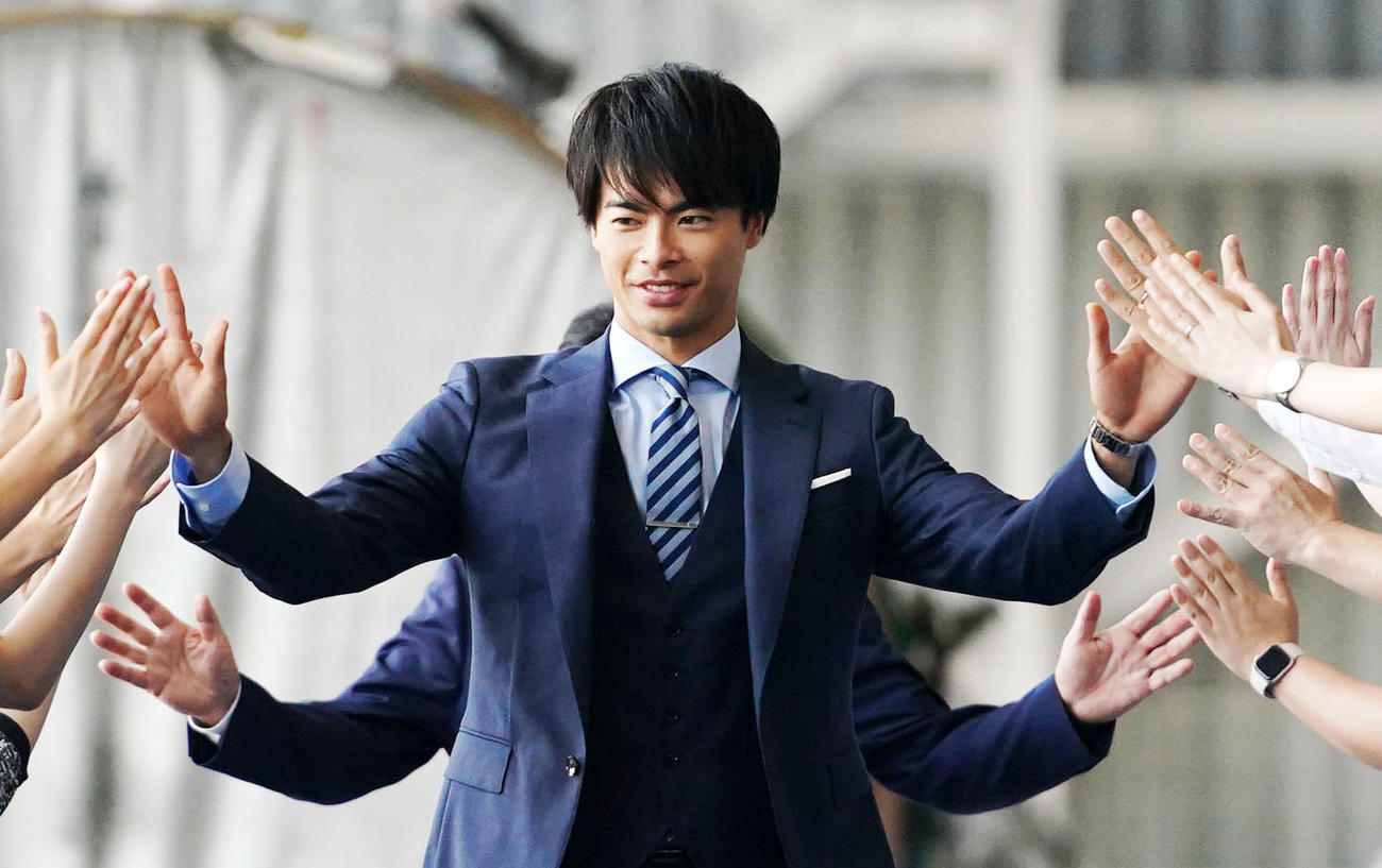 ハイタッチをしてANAスポンサー契約発表会に臨む三笘（撮影・横山健太）