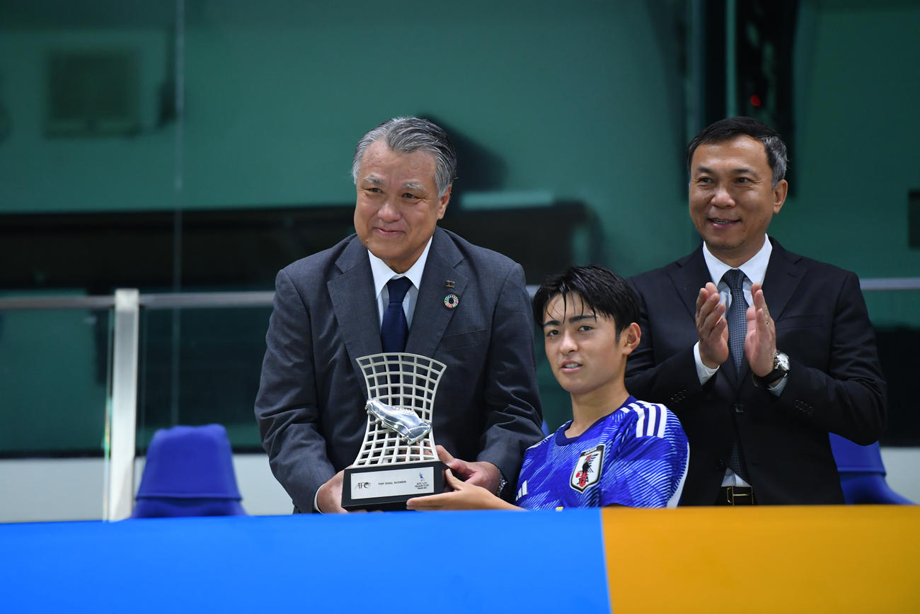 日本対韓国　優勝し得点王＆MVPに選ばれた名和田（中央）は、JFA田嶋会長（左）からトロフィーを受け取る（C）2023　AFC