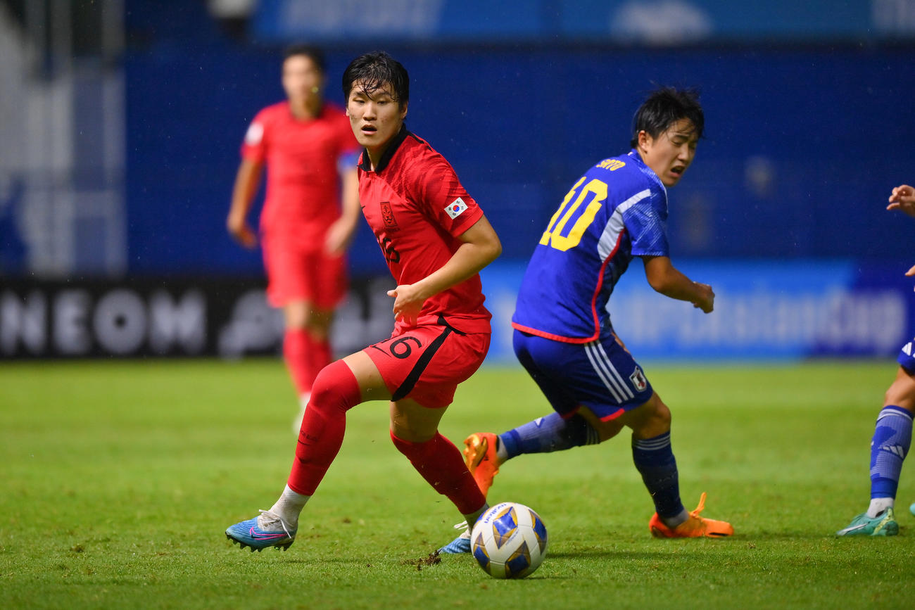 韓国選手と競り合う佐藤龍之介（右）