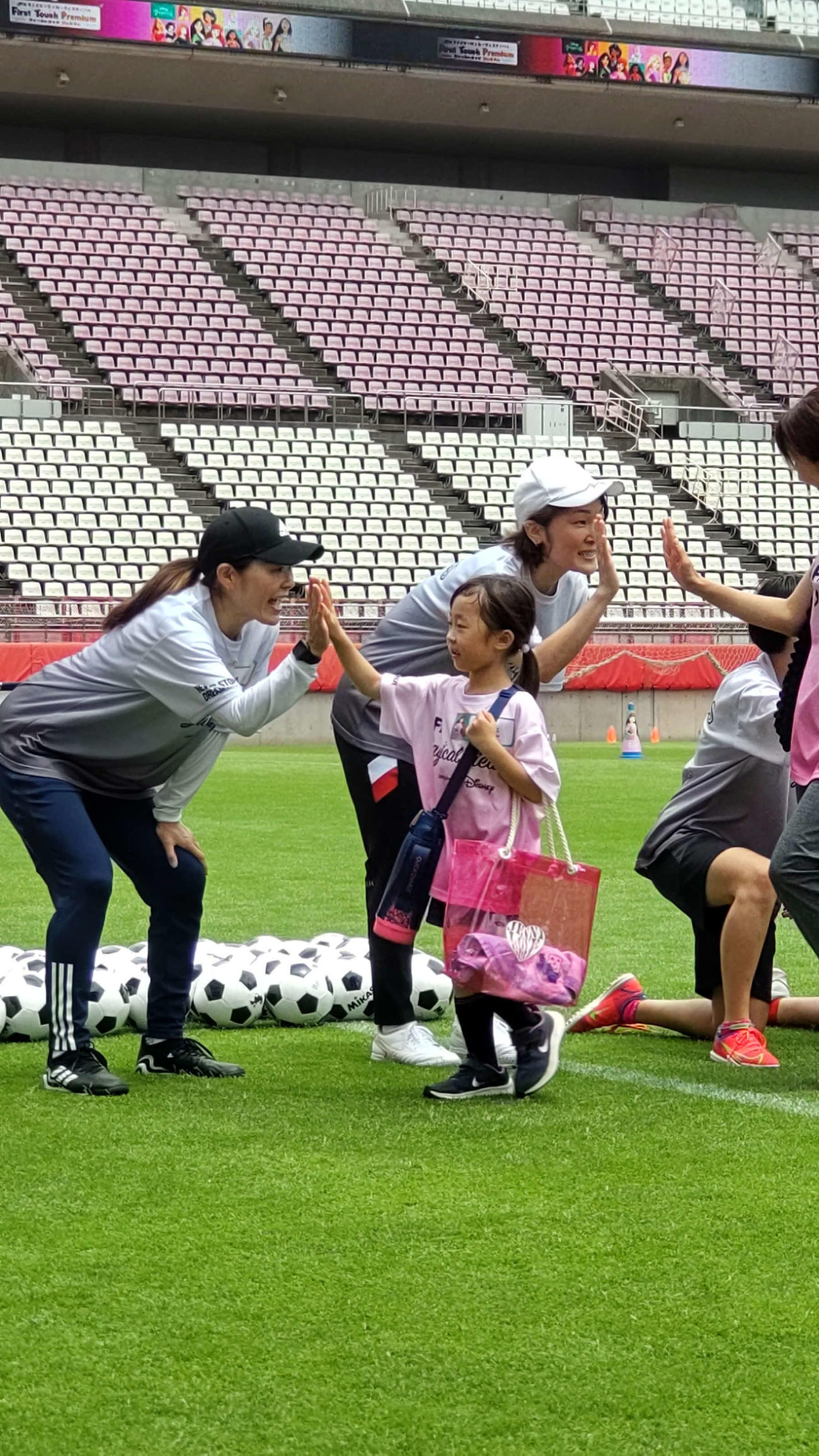 鹿島スタジアムでのJFAとウォルト・ディズニー・ジャパン社によるイベントに参加した子供とハイタッチする澤穂希さん（左）と阪口夢穂さん