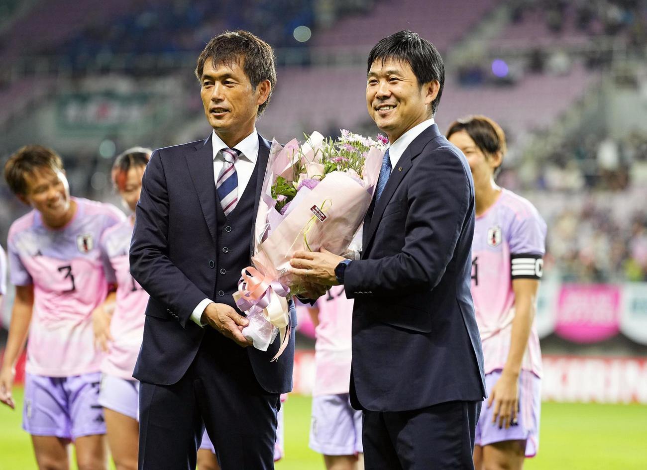 パナマ戦後のセレモニーで、男子日本代表の森保監督（右）から花束を受け取る池田監督（共同）