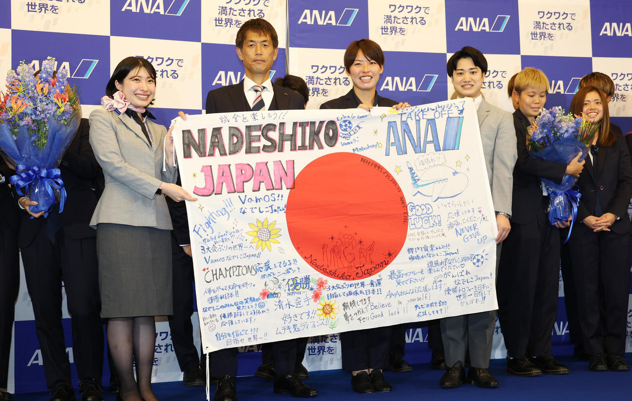 なでしこジャパンの池田監督（中央左）、熊谷主将（同右）は応援メッセージ入りフラッグを受けとる（撮影・野上伸悟）