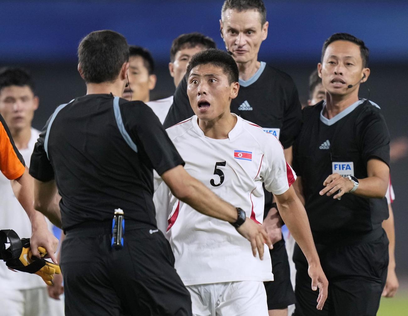 日本に敗れ、試合終了後に審判に詰め寄る北朝鮮の選手＝杭州（共同）