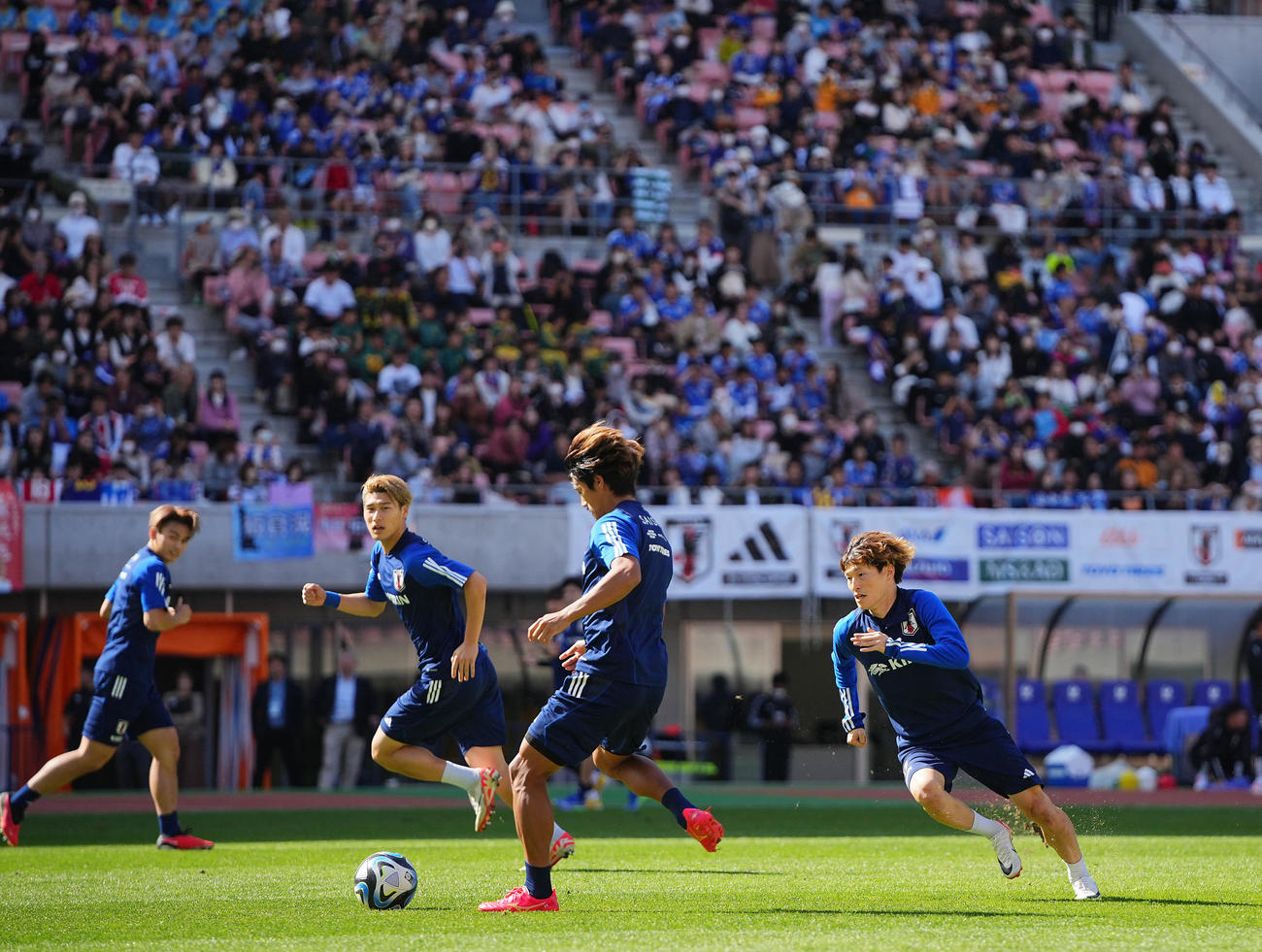大勢のファンがスタンドから見つめる中練習に臨む日本代表の選手たち。右から古橋、守田、橋岡、上田（撮影・垰建太）