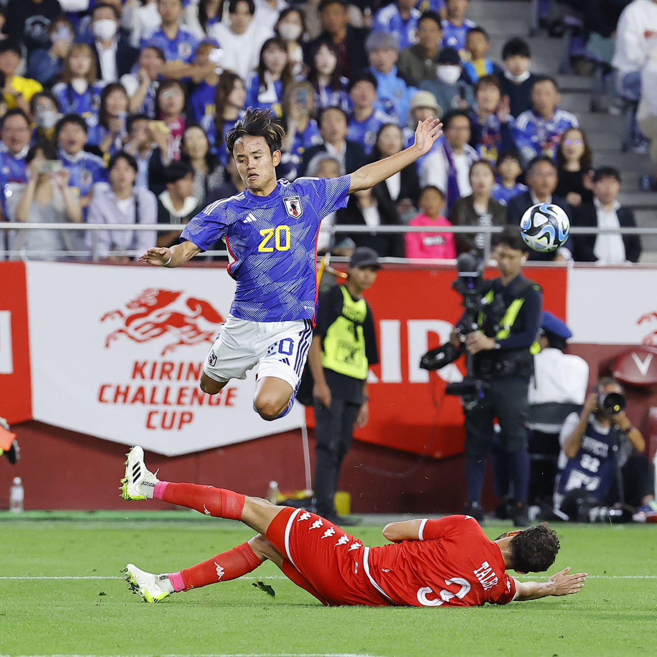 日本対チュニジア　後半、ボールをカットされたタルビ（下）を跳び越える久保（撮影・藤尾明華）