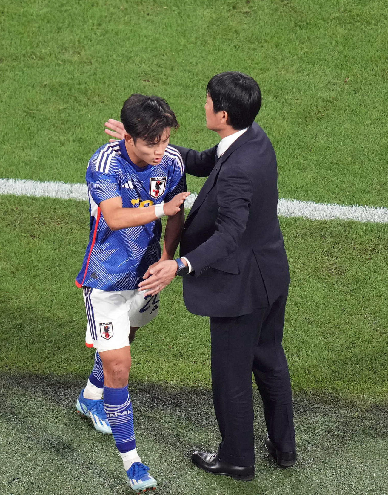 日本対チュニジア　後半、交代し、森保監督（右）からねぎらいを受ける久保（撮影・狩俣裕三）
