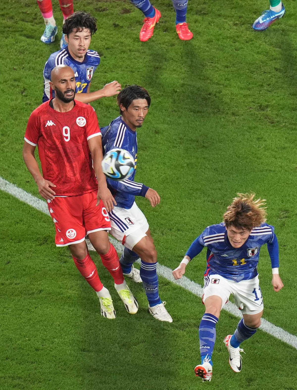 日本対チュニジア　前半、ゴール前で守田英正（中央）らと競り合うイッサム・ジェバリ（左＝G大阪）。手前は古橋（撮影・狩俣裕三）