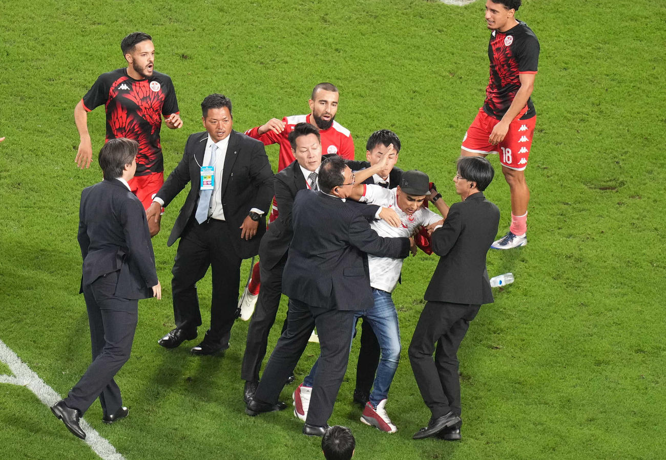 日本対チュニジア　試合後、ピッチに乱入し、スタッフに取り押さえられるサポーター（撮影・狩俣裕三）