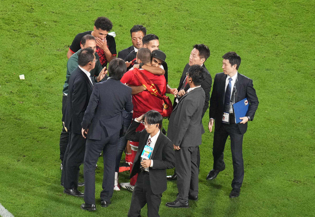 日本対チュニジア　試合後、ピッチに乱入し、チュニジア代表スリティ（手前）に抱きつくサポーター（撮影・狩俣裕三）