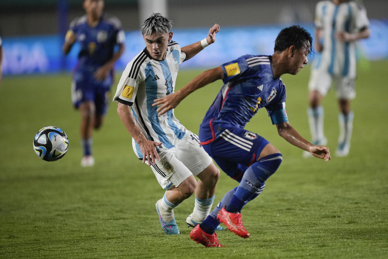 日本DF小杉啓太がアルゼンチンMFロペスと競り合う（AP）