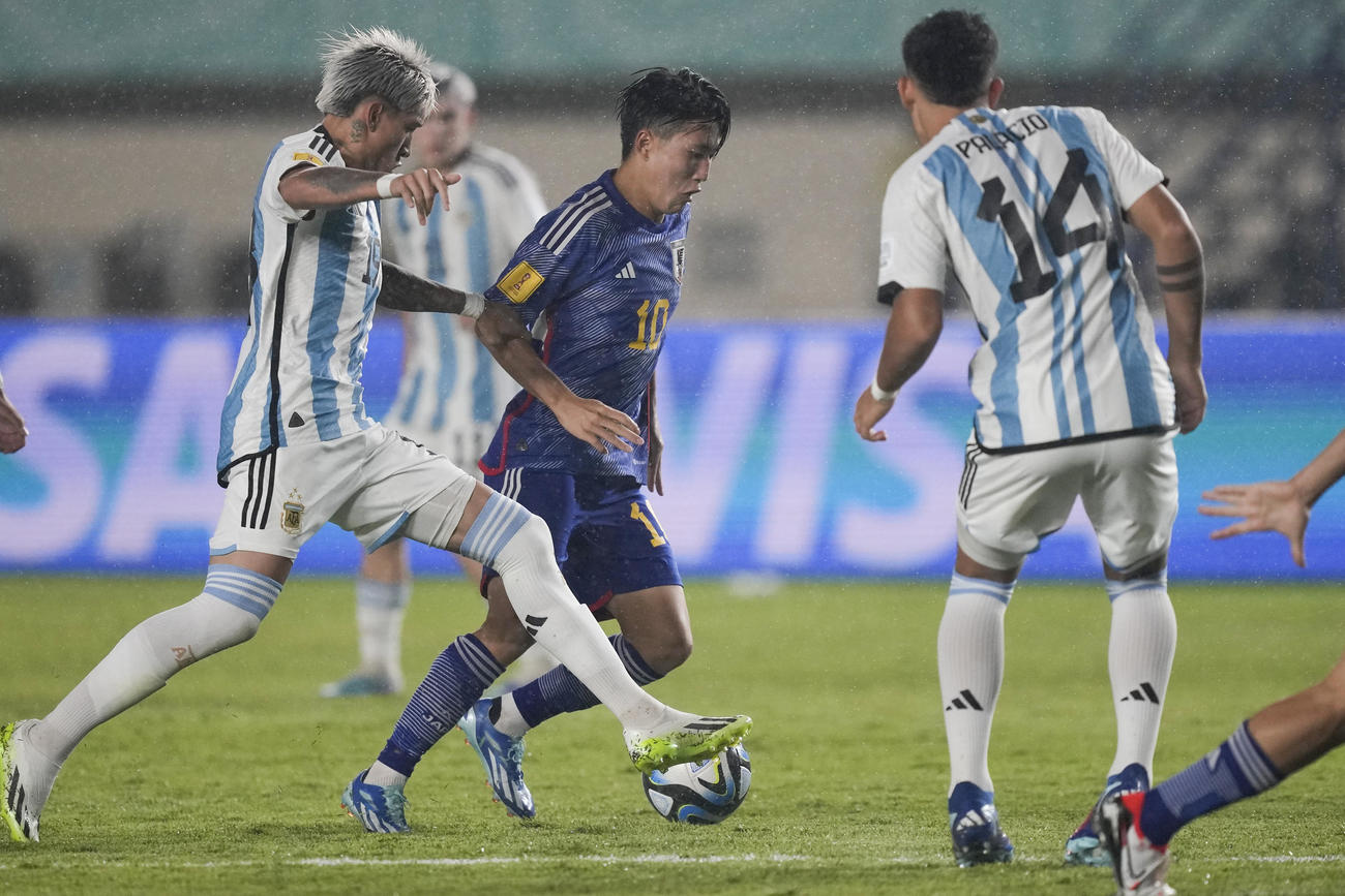 日本MF佐藤龍之介がアルゼンチン選手相手に突破を図る（AP）