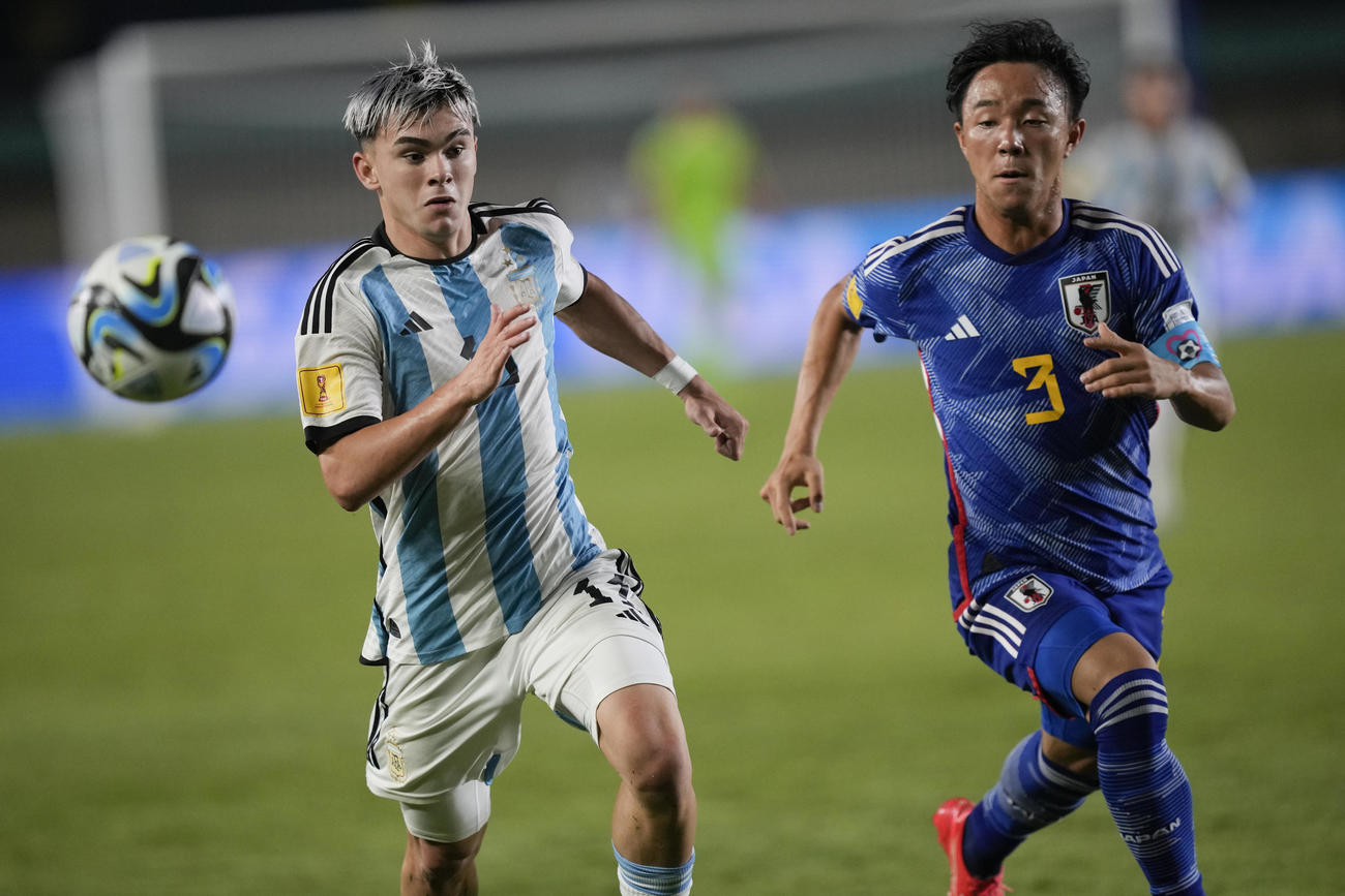 日本DF小杉啓太がアルゼンチンMFロペスと競り合う（AP）