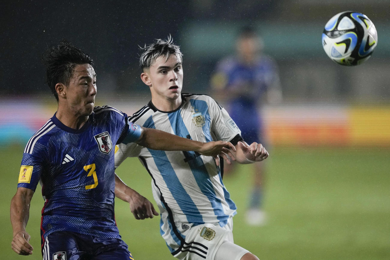 日本DF小杉啓太がアルゼンチンMFロペスと競り合う（AP）