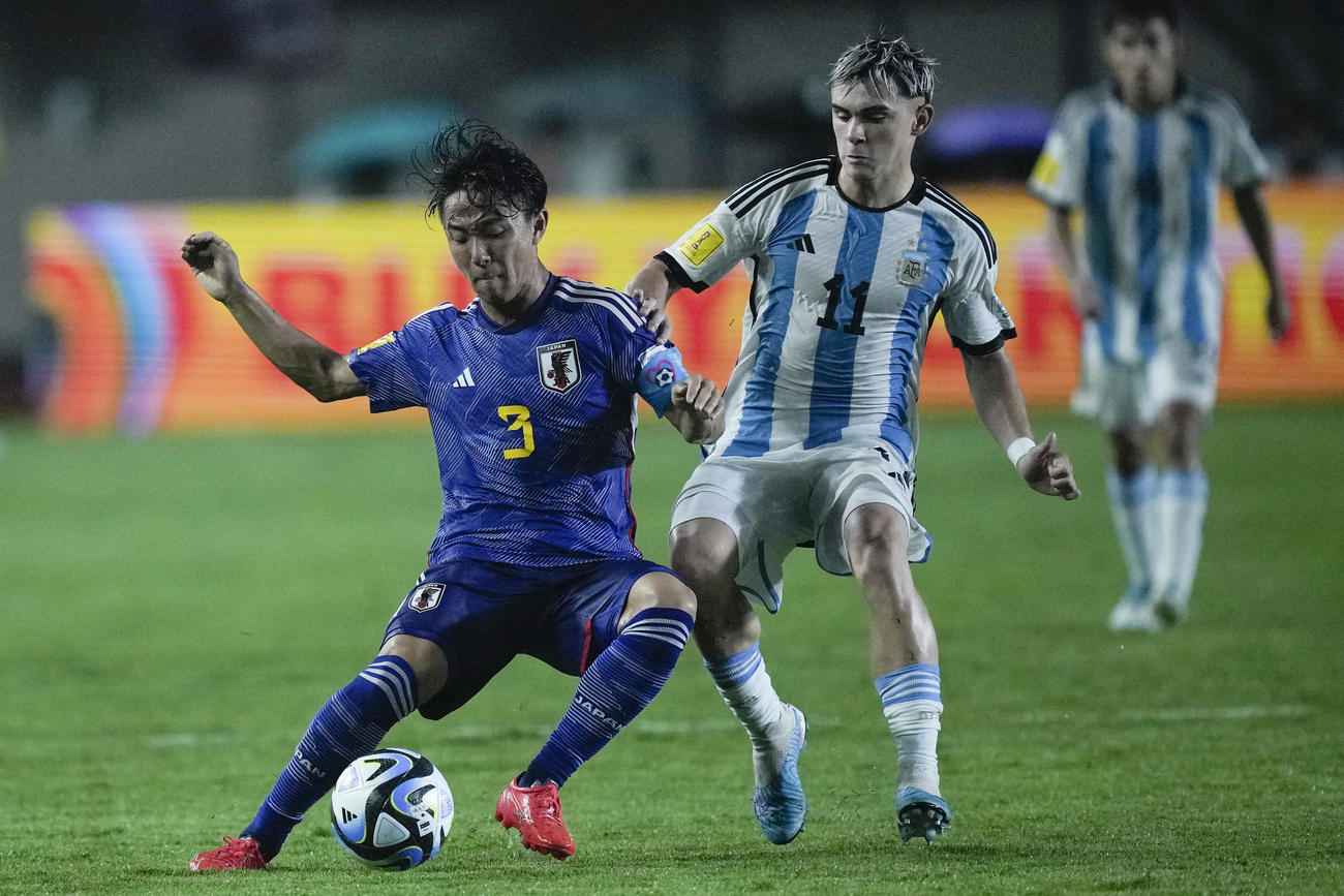 日本DF小杉啓太がアルゼンチンMFロペスと競り合う（AP）