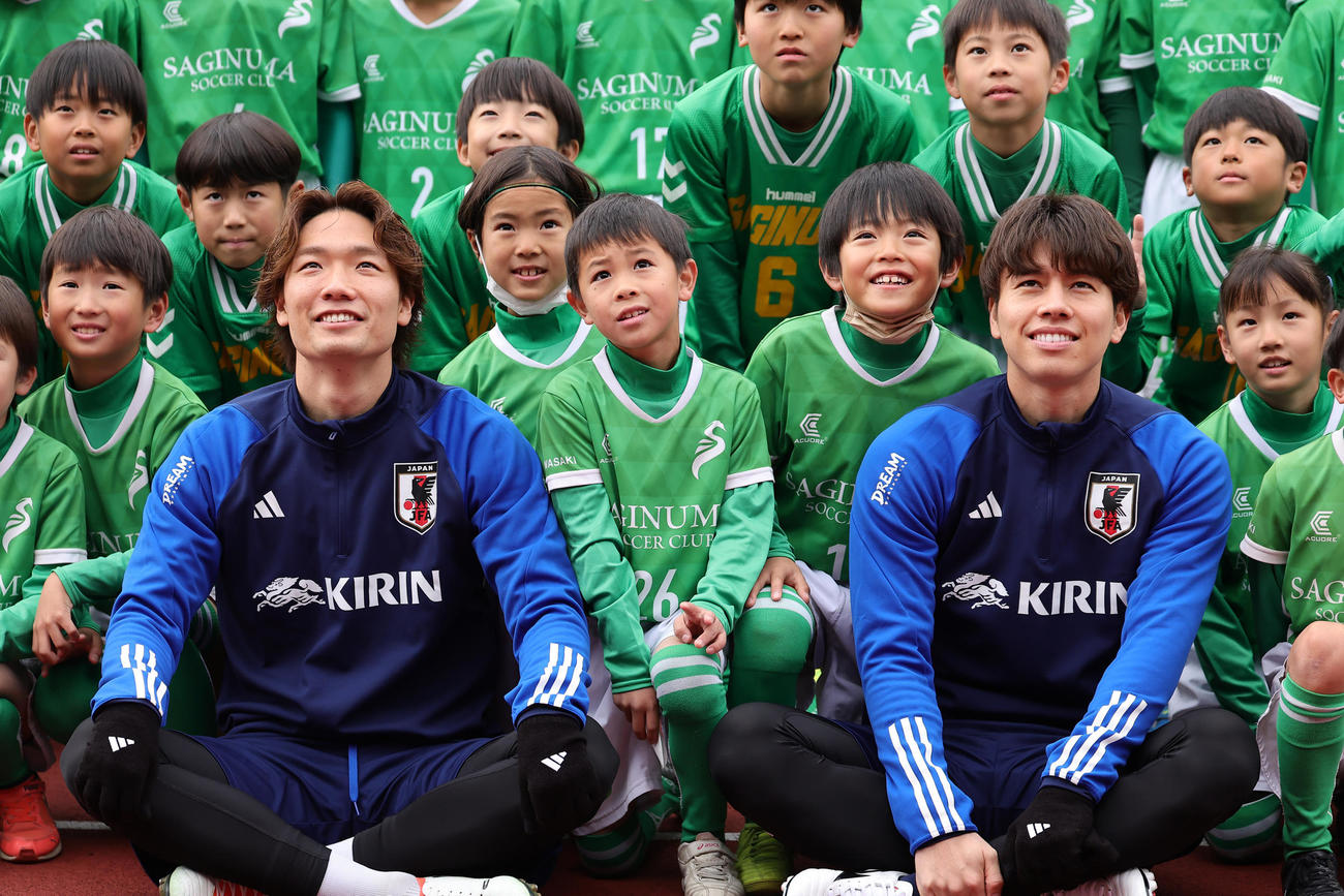 練習前、子どもたちとの記念撮影に笑顔を見せる板倉（左）と田中（撮影・足立雅史）