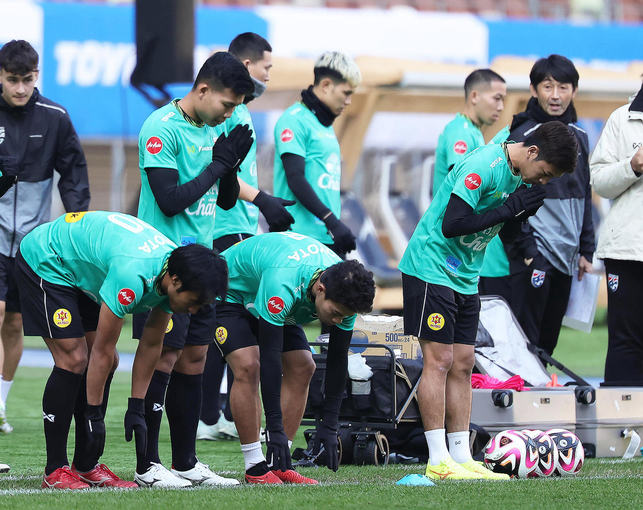 祈りをささげピッチに入るタイ代表の選手たち。後方右端は石井監督（撮影・足立雅史）